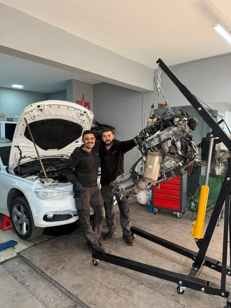 EF Garage ustaları atölyede motor vinciyle indirilen motorun yanında